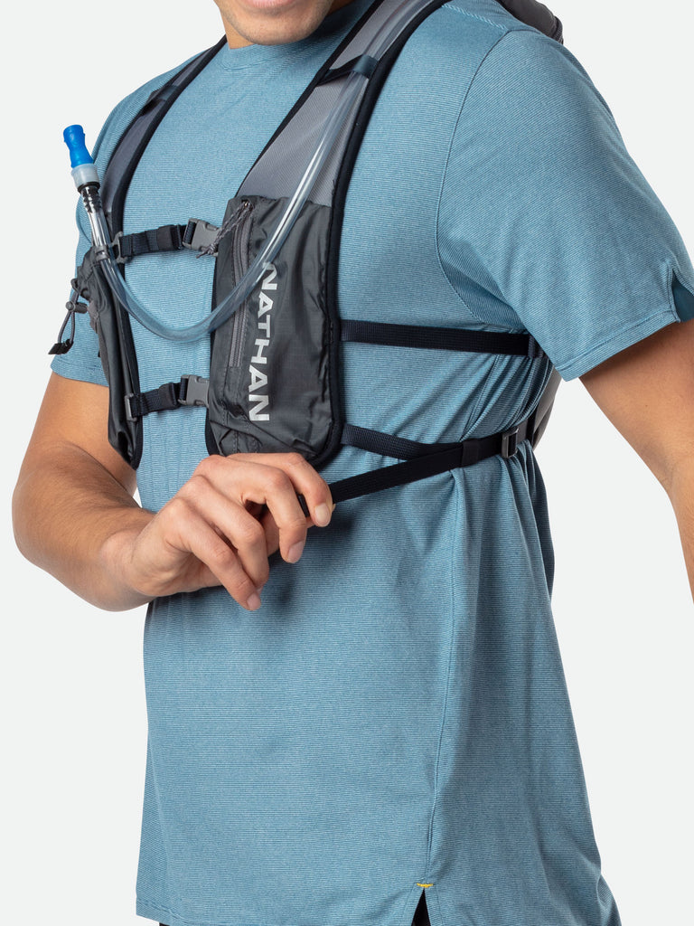 Nathan QuickStart 2.0 3 Liter Hydration Pack - Gravity Gray/Reflective Silver - On Model - Model Tightening Sternum Straps For Better Fit