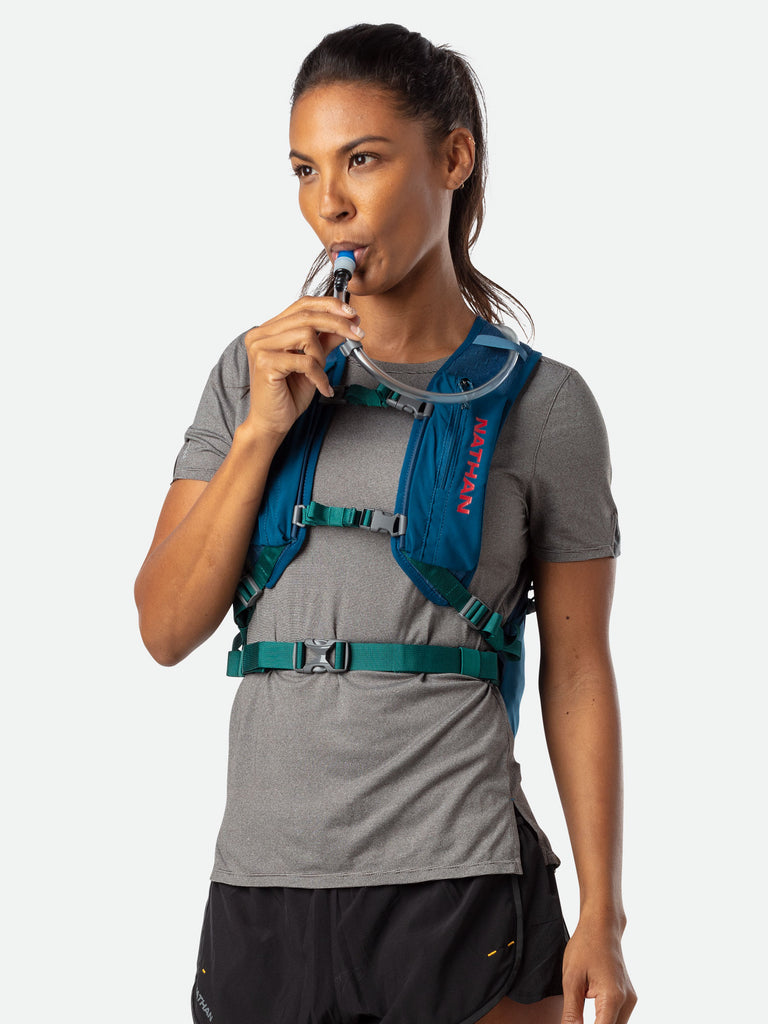 Nathan Crossover 15 Liter Hydration Pack - Marine Blue/Hot Red - On Model - Sipping From High Flow Bite Valve