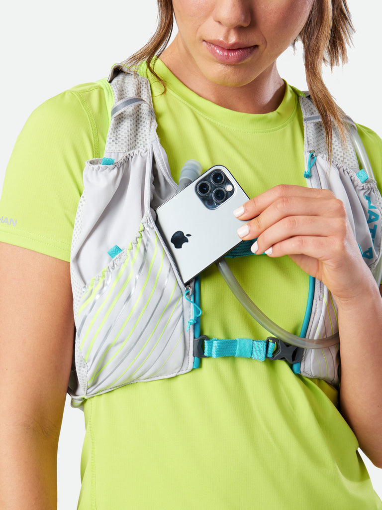 Nathan Pinnacle 12 Liter Women’s Hydration Race Vest - Vapor Grey/Caribbean Blue - Female Runner Pulling Cell Phone From Storage Pocket