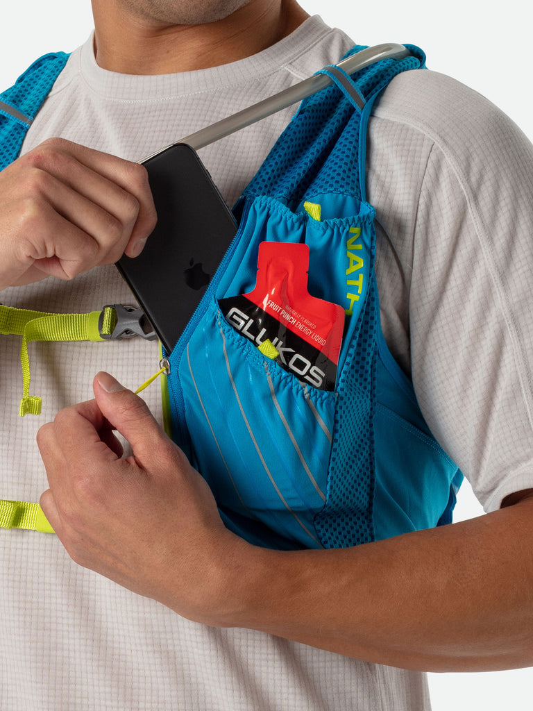Nathan Pinnacle 12 Liter Unisex Hydration Race Vest - Blue Me Away/Finish Lime Green - Male Runner Pulling Cell Phone From Storage Pocket