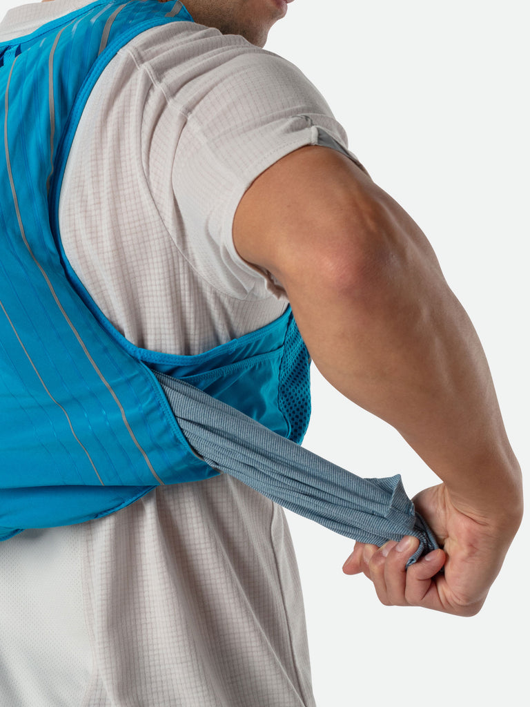 Nathan Pinnacle 12 Liter Unisex Hydration Race Vest - Blue Me Away/Finish Lime Green - Male Runner Pulling Clothing From Easy-Access Kangaroo Pocket