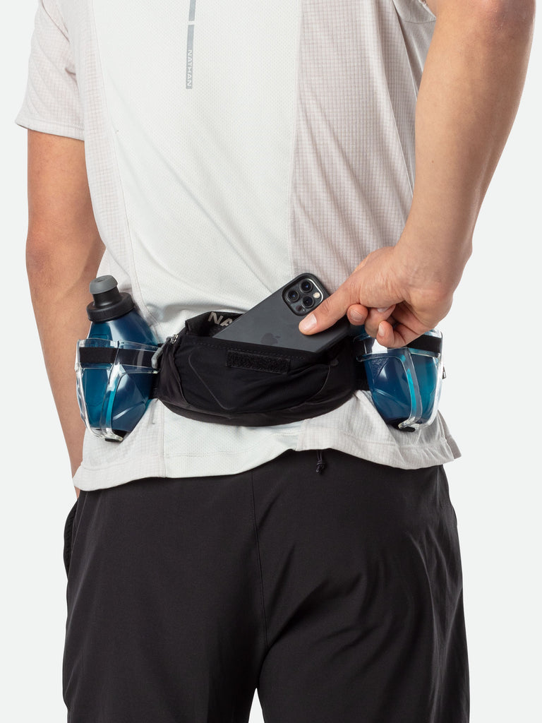 Nathan TrailMix Plus Hydration Belt - Black/Reflective Silver - On Model - Pulling Cell Phone From Pocket