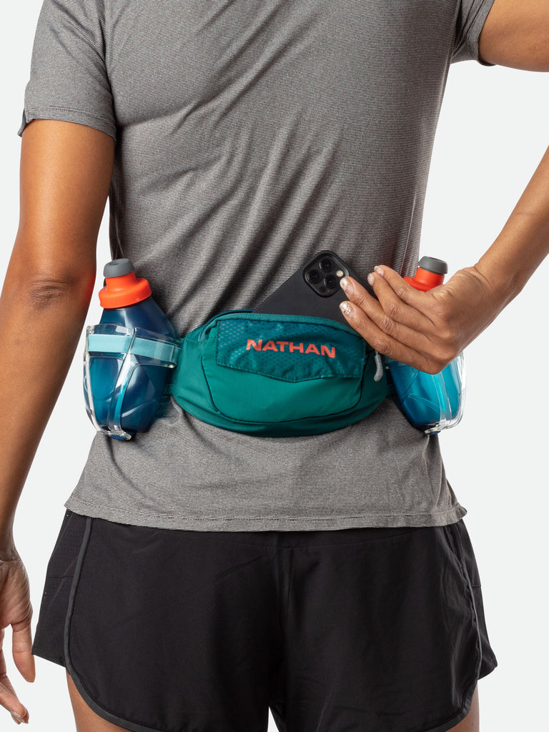 Nathan TrailMix Plus Hydration Belt - Storm Green/Hot Red - On Model - Pulling Cell Phone From Pocket