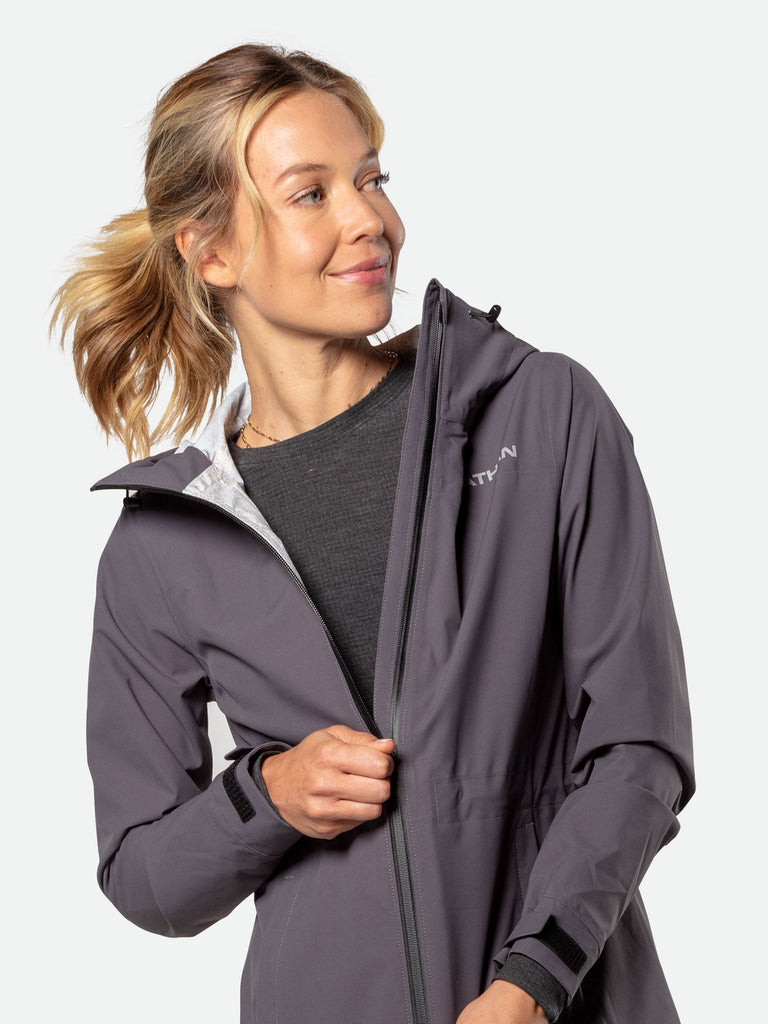 Nathan Women’s Protector Rain Jacket – Dark Charcoal - On Model – Pulling Zipper Down on Chest Pocket