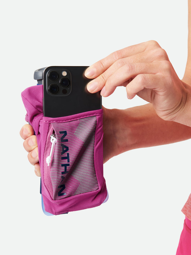 Nathan QuickSqueeze 12oz Hydration Handheld - Magenta/Estate Blue - Runner Pulling Out Cell Phone From Pocket of Handheld