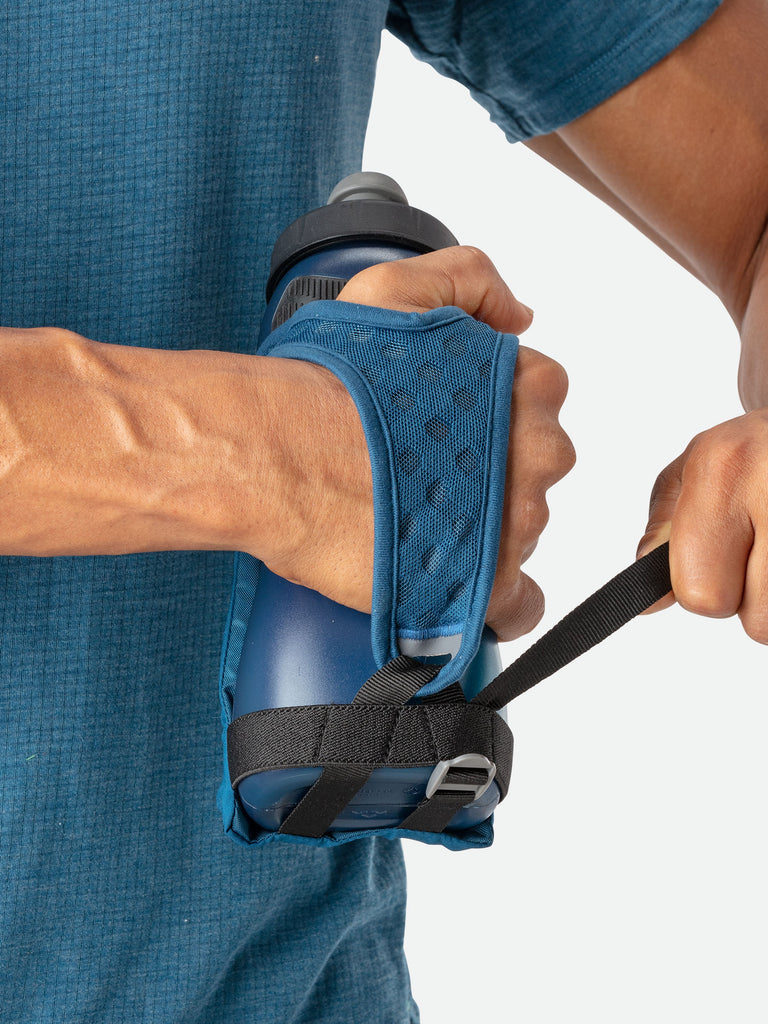 Nathan QuickSqueeze 22oz Hydration Handheld - Marine Blue/Mint - Runner Pulling Strap to Tighten Handheld Around the Palm
